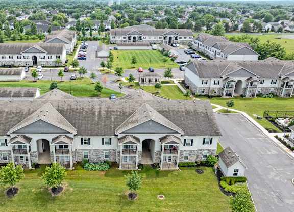 A bird's eye view of a residential area with houses and a parking lot.