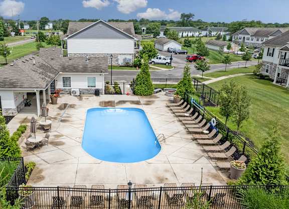 A large white house with a blue pool in the backyard.