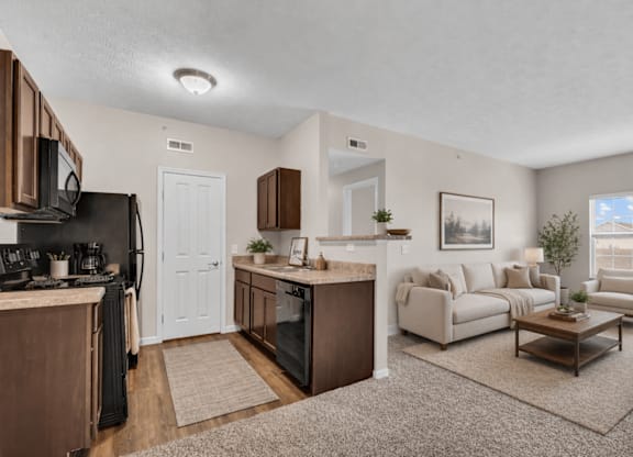 A well-lit, spacious living room with a kitchen area in the background.
