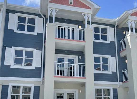 A multi-story building with a red roof and white railings.