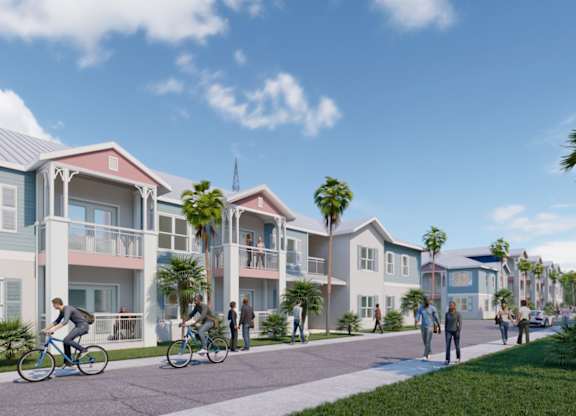 A group of people are riding bikes on a path in front of a row of townhouses.