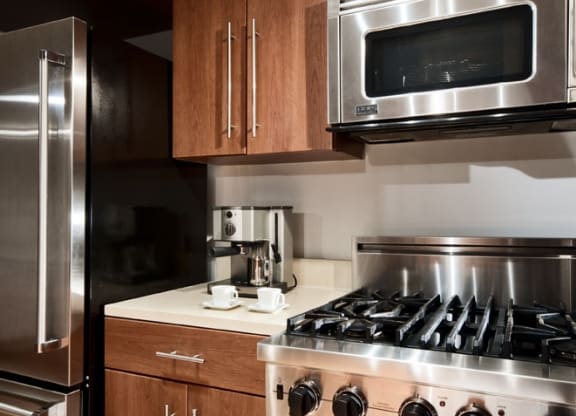 a kitchen with a stove top oven next to a refrigerator  at The Sheffield Englewood, Englewood, NJ