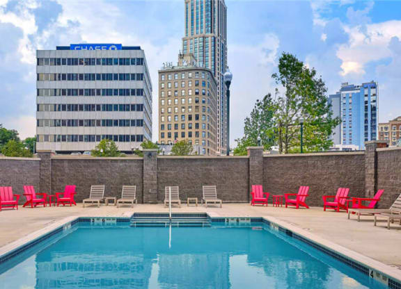 a pool with red chairs and a city in the background  at Shearwood Station, New Rochelle, NY