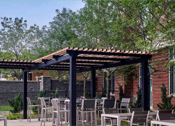 a patio with tables and chairs and a pergola at Shearwood Station, New York
