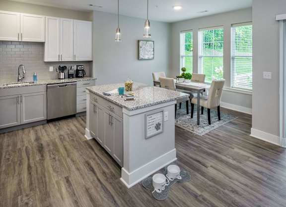 A kitchen with a table and chairs in the middle of the room.