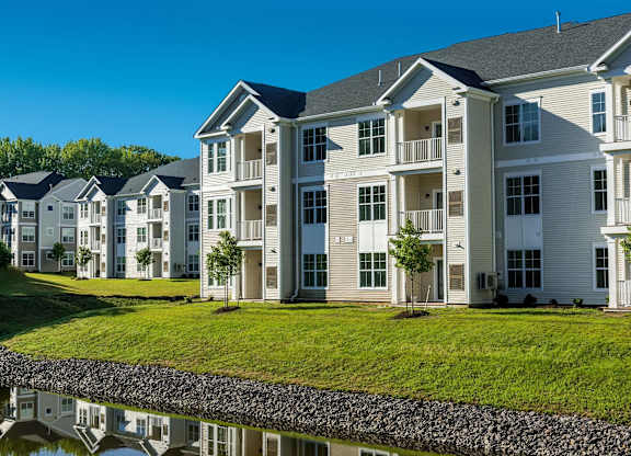 A row of houses with a pond in front.