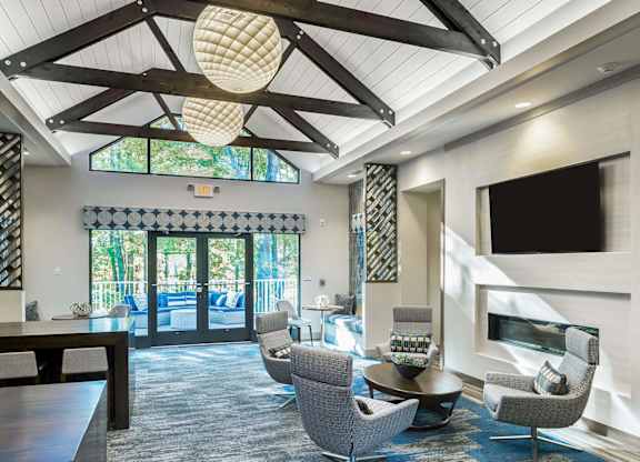 A living room with a grey carpet and a wooden ceiling.