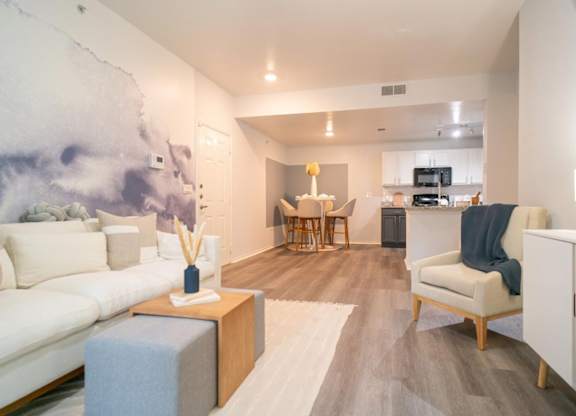 A living room with a white couch and a grey ottoman.