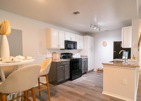 A kitchen with a white table and chairs.