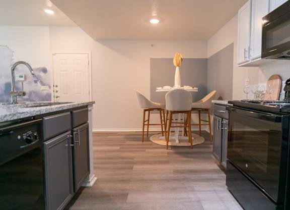 A kitchen with a table and chairs in the middle.