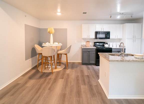 A kitchen with a table and chairs in the middle of the room.