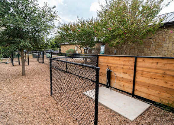A playground with a black fence and a wooden wall.
