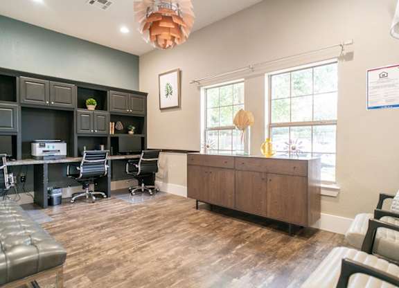 A room with a desk, chairs, and a couch.