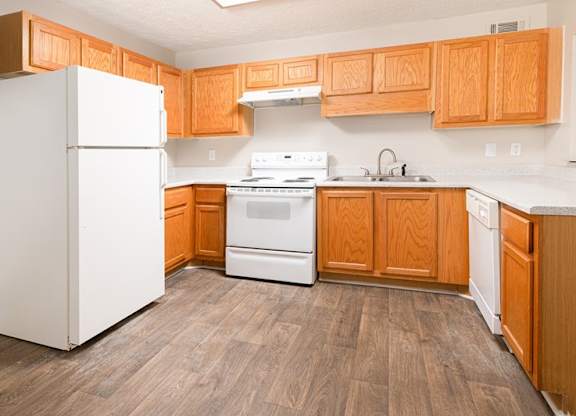 A kitchen with wooden cabinets and a white refrigerator.