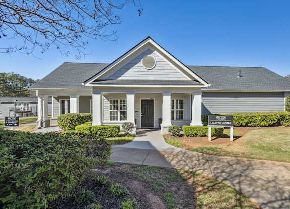 A house with a grey roof and a sign that says "LEARN CENTER".