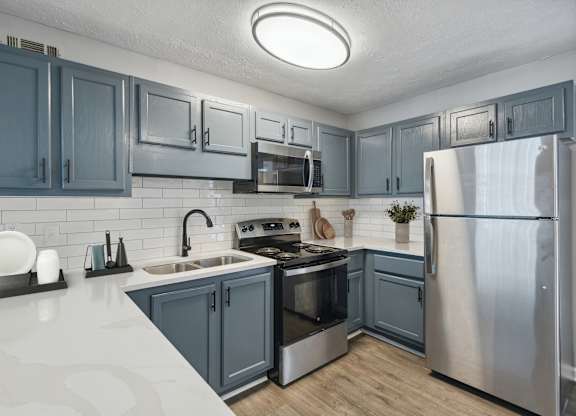 A kitchen with a stove top oven and a refrigerator.