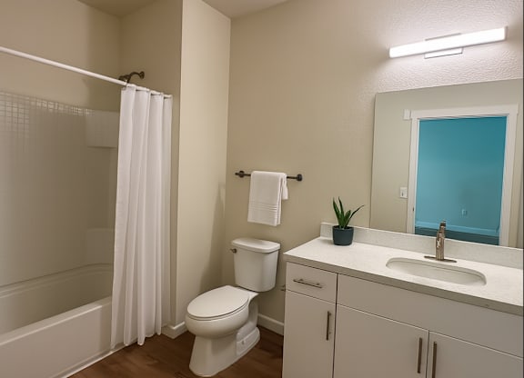 A white toilet sits in a bathroom next to a white sink.