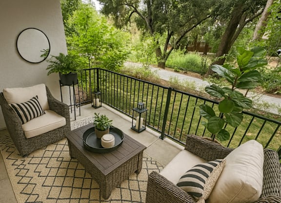 A patio with a sofa, chair, and table.