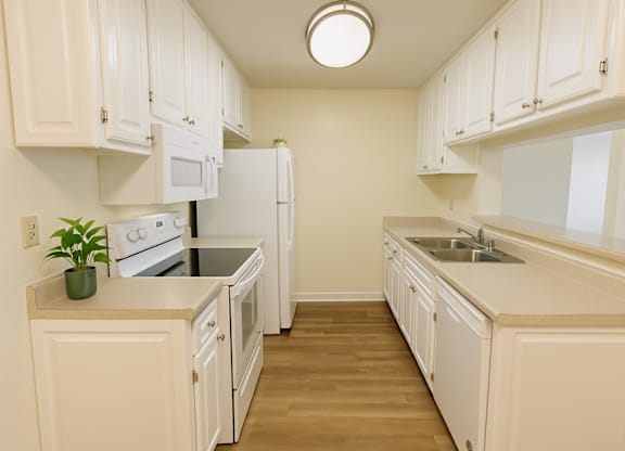 A kitchen with white cabinets and appliances.