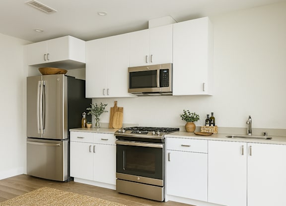 A modern kitchen with white cabinets and stainless steel appliances.at Edgeway Plaza, California, 94928