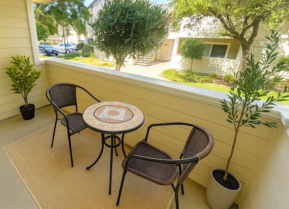 A patio with a table and chairs overlooking a street.