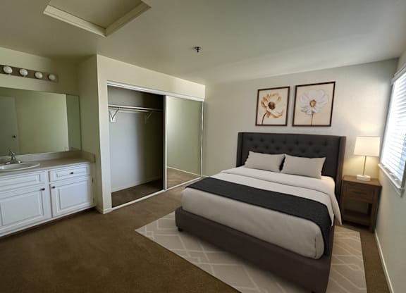 A bedroom with a large bed and a vanity with a mirror.