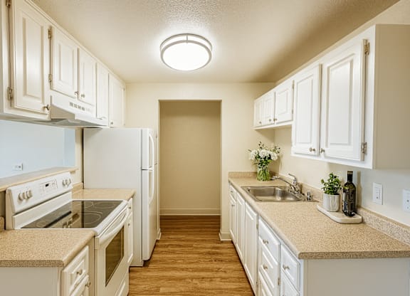 A kitchen with white appliances and cabinets.