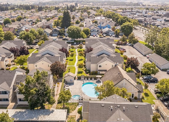 A bird's eye view of a residential area with houses and a swimming pool.