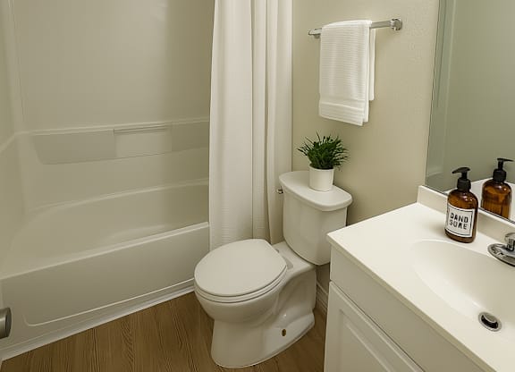 A white toilet sits next to a white sink in a small bathroom.