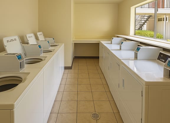 A row of automatic touchless hand dryers are lined up on a counter.