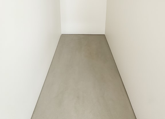 A white hallway with a grey floor.