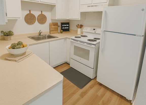 A white kitchen with a sink, stove, and refrigerator.