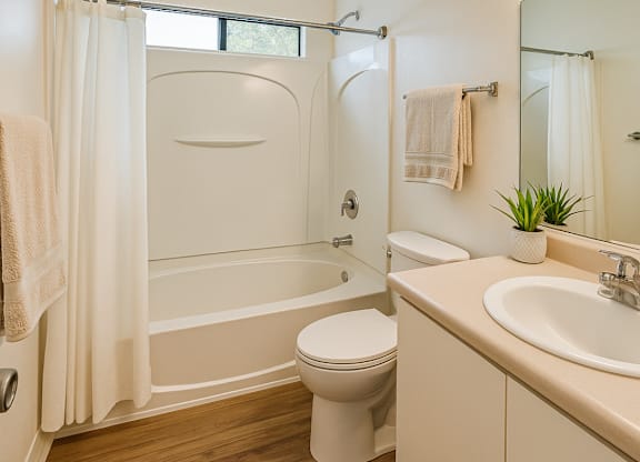 A white bathroom with a toilet, sink, and bathtub.at Hamilton Woods, Novato