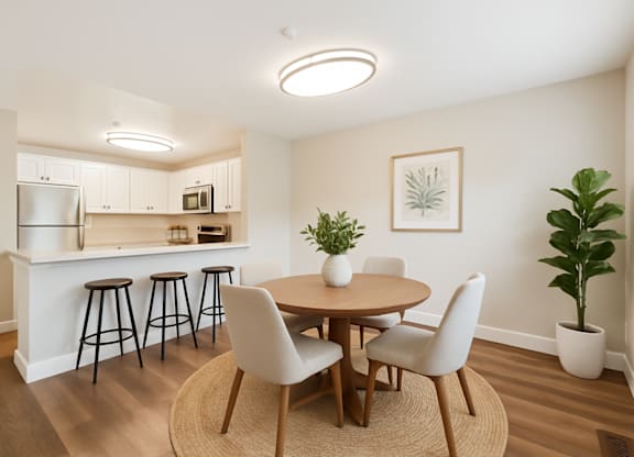 A kitchen with a bar and a dining table with chairs.