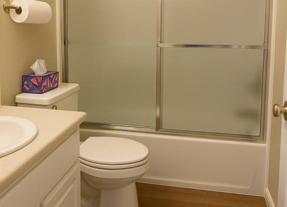 A white toilet sits next to a sink in a bathroom.