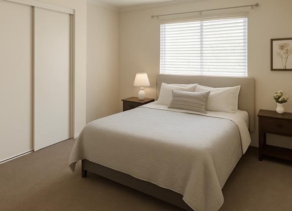 A bedroom with a bed, nightstand, and lamp.