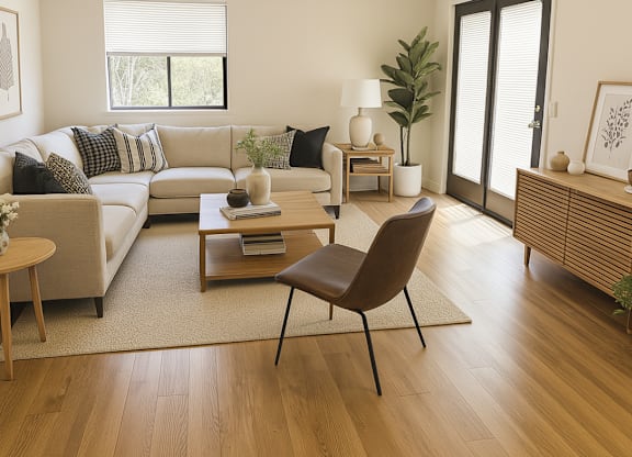 A living room with a sofa, a chair, a table, and a plant.