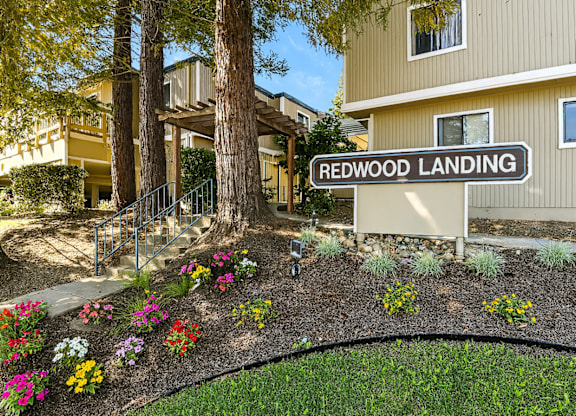 A sign that says Redwood Landing in front of a building.