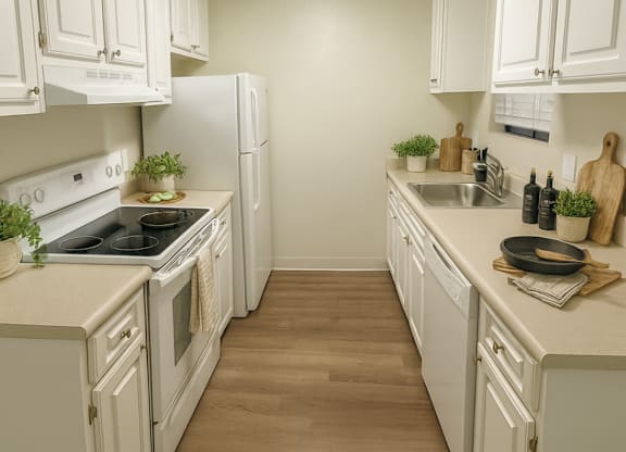 A kitchen with white cabinets and a wooden floor.