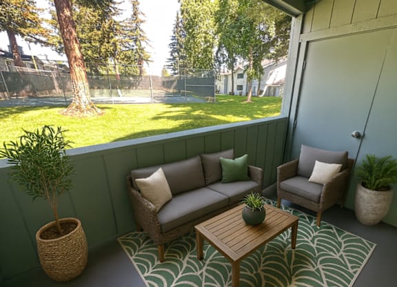 A patio with a couch, chair, and table.