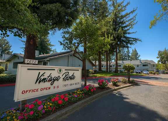 A sign for Vintage Pines with an office open sign and a phone number.