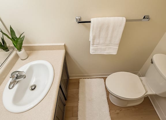 A white towel hangs on a towel rack in a bathroom.