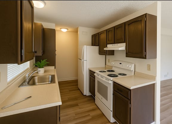 A kitchen with brown cabinets and white appliances.