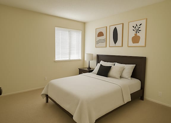A bedroom with a bed, pillows, and pictures on the wall.