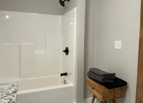 a white bathroom with a tub and a sink