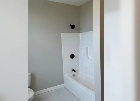 a white bathroom with a tub and a toilet