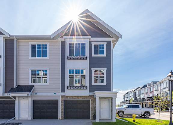 A modern two-story house with a garage and a car parked in front.