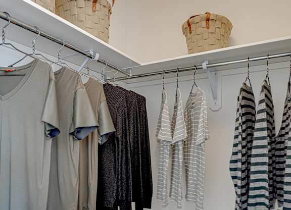 Clothes hanging on a rack in a room.