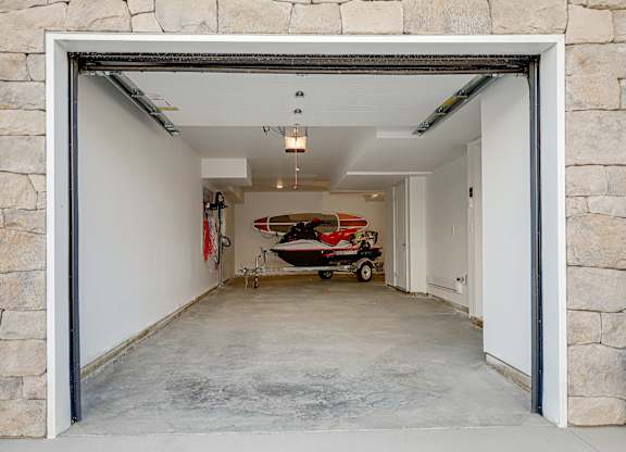 A garage with a red and white boat inside.