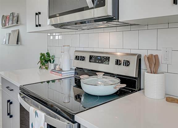 A modern kitchen with a stove top oven and a microwave above it.
